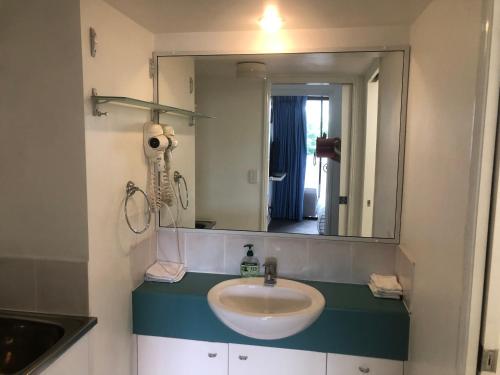 uma casa de banho com um lavatório e um espelho em SOUTH BRISBANE APARTMENTS Free Parking em Brisbane