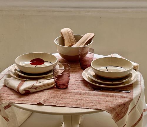 a table with plates and bowls on a table at La Maison Plume, Appart Boutique in Saint-Rémy-de-Provence