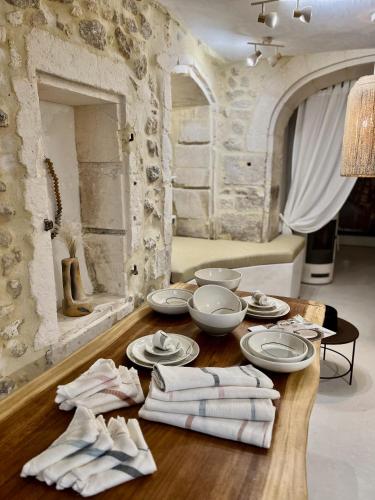 - une table avec des assiettes et de la vaisselle dans une pièce dans l'établissement La Maison Plume, Appart Boutique, à Saint-Rémy-de-Provence