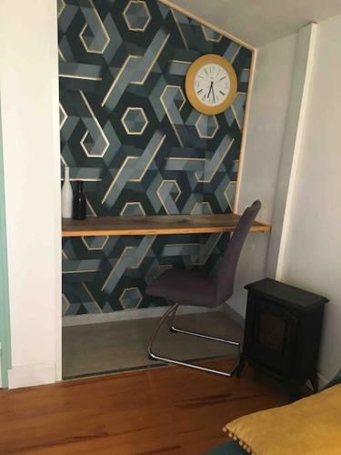貝爾凱爾的住宿－Charmant T2 indépendant，一间房间,墙上有椅子和时钟