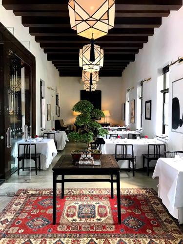 a dining room with a table and white tables at Rachamankha Hotel in Chiang Mai
