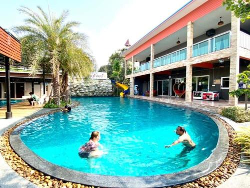 two women swimming in the pool at a resort at บ้านสวนชมจันทร์ กำแพงแสน 