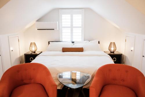 een slaapkamer met een bed met 2 stoelen en een tafel bij Cowry Acres - The First House Villa w Hot Tub in New Hope