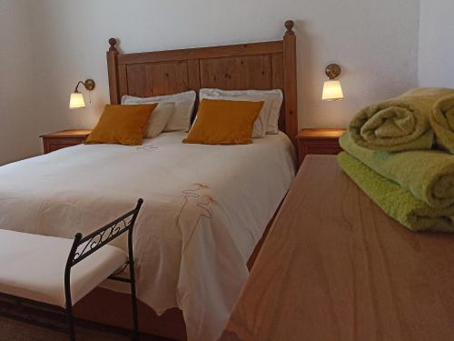 Un dormitorio con una gran cama blanca con almohadas naranjas. en La Barrica, en Soo