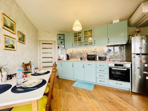 uma cozinha com armários verdes, uma mesa e um frigorífico em PANORAMA-М em Vratsa