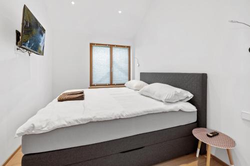 a bedroom with a large bed with white sheets and a window at Luxus Chalet Max in Glanz an der Weinstraße