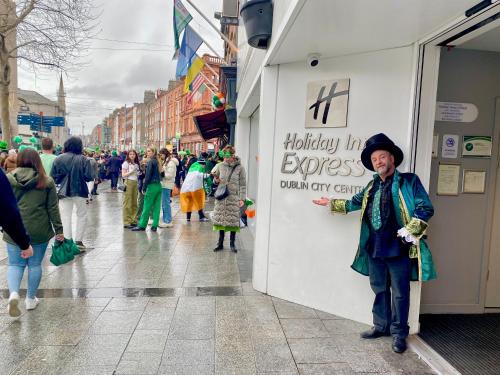 Un uomo in piedi davanti a un negozio in una strada di Holiday Inn Express Dublin City Centre, an IHG Hotel a Dublino