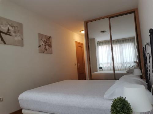 a bedroom with a bed and a large mirror at Apartamento Llanes Mar y Monte in Llanes