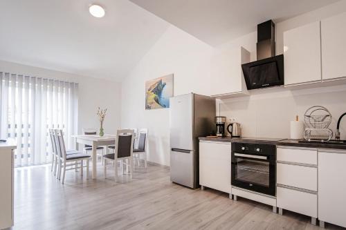 een keuken en eetkamer met een tafel en stoelen bij Apartamenty DM in Kłodzko