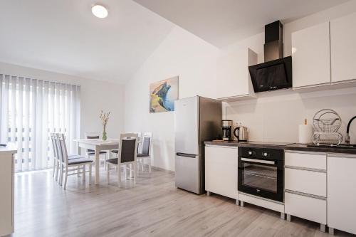 a kitchen and dining room with a table and chairs at Apartamenty DM in Kłodzko