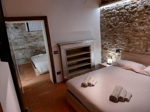 um quarto com uma cama e uma parede de pedra em Caolzio18 em CastellʼArquato