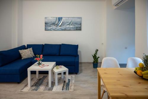 a living room with a blue couch and a table at Apartment Montona in Pula