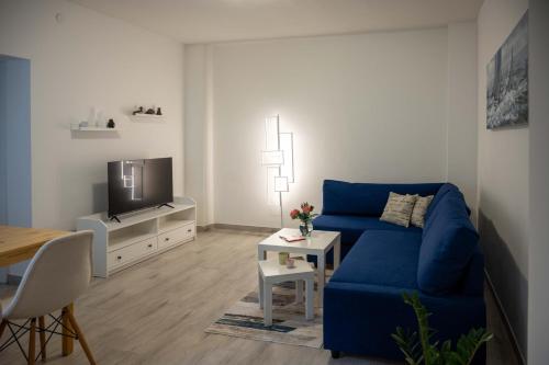 a living room with a blue couch and a tv at Apartment Montona in Pula