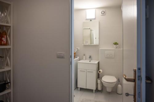 a white bathroom with a toilet and a sink at Apartment Montona in Pula
