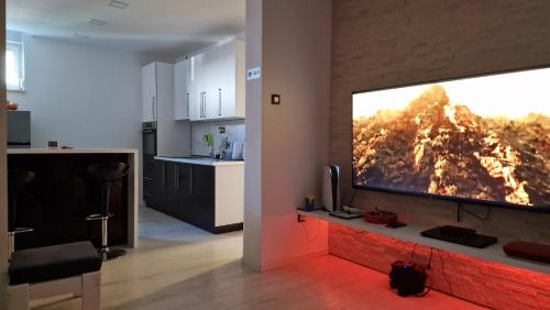 uma sala de estar com uma grande televisão de ecrã plano na parede em Wellness apartment BLACK-WHITE em Široki Brijeg