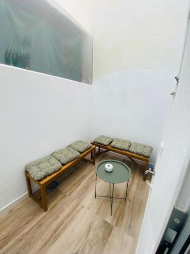 een kamer met 2 banken, een tafel en een raam bij Piso San Eloy - Centro de Cordoba in Córdoba