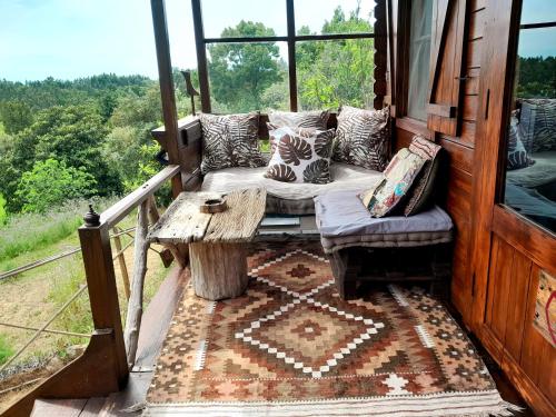 a porch with a couch and a table on a balcony at Casa do Sobreiro 2 in Serra das Alhadas