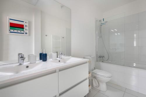 a white bathroom with a sink and a toilet at Appartement moderne pour 4 a La Baule in La Baule