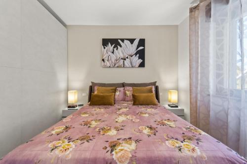 a bedroom with a large pink bed with two lamps at Ca' Alessandra in Carloforte