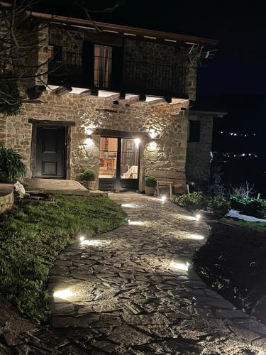 a stone house at night with lights on the walkway at Posada Casa Guadamillas in Bustancilles
