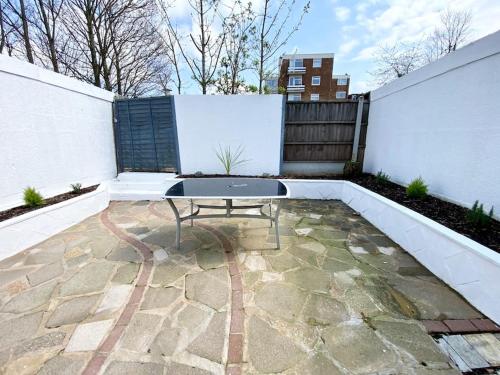 a patio with a table and a fence at Charming Seaside Cottage in Leigh-on-Sea in Southend-on-Sea