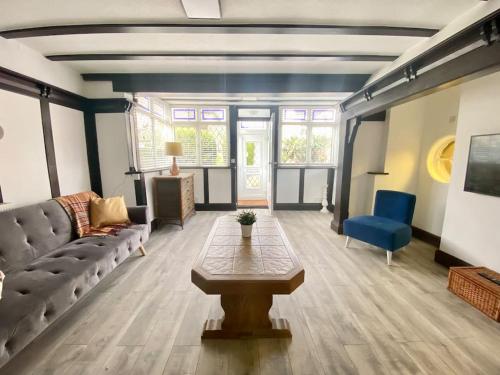 a living room with a couch and a table at Charming Seaside Cottage in Leigh-on-Sea in Southend-on-Sea