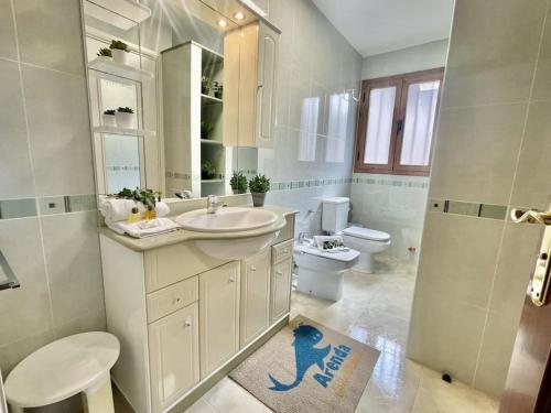 bagno bianco con lavandino e servizi igienici di Arenda Clara villa con piscina privada al lado de la playa a Hospitalet de l'Infant