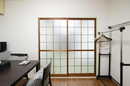 a room with a large glass door with a table at Osaka U-Shuku in Osaka