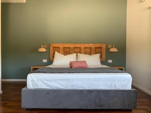 a bedroom with a large bed with two lamps on the wall at PetraSicula Apartment in Acitrezza