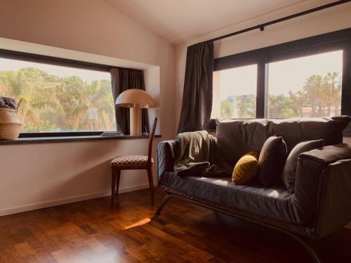 a living room with a couch and a large window at PetraSicula Apartment in Acitrezza