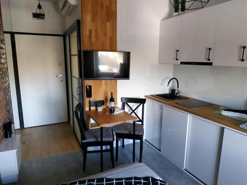 a small kitchen with a table and chairs and a sink at theApartments Manufaktura in Łódź