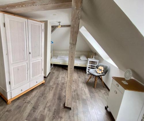 a attic room with a bed and a chair at Ferienwohnung Dölzig in Schkeuditz
