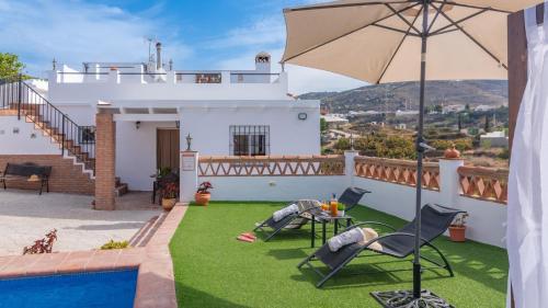 a house with a yard with a pool and an umbrella at Villa Naiara Torrox by Ruralidays in Torrox