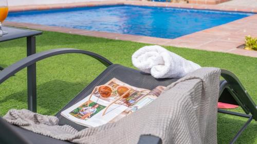 a chair with a towel on it next to a pool at Villa Naiara Torrox by Ruralidays in Torrox