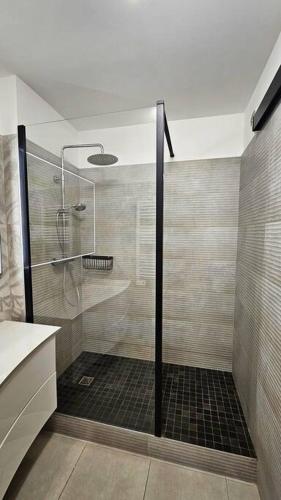une douche avec une porte vitrée dans une salle de bain dans l'établissement Les Marches du Soleil, à Sète