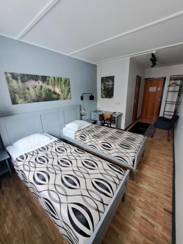 a bedroom with two beds and a table at Pesa Hotel in Põlva