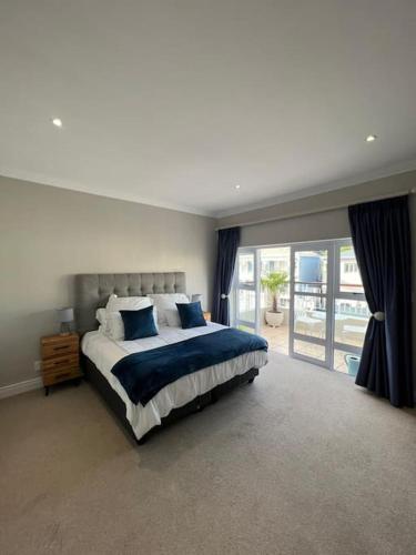 sypialnia z dużym łóżkiem z niebieskimi poduszkami w obiekcie Elgin Townhouse-Excellent location w Kapsztadzie
