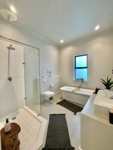 a bathroom with a tub and a toilet and a sink at LTB - Kalm Riverside Living in Malgas