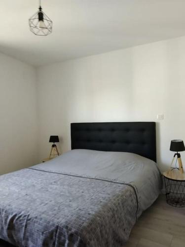 une chambre avec un grand lit avec deux lampes dans l'établissement Petite maison de l'ancien rivage, à Boulogne-sur-Mer