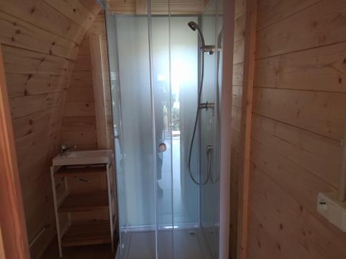 a bathroom with a shower in a wooden wall at Bungalow 3 personas - Camping Playa de Tapia in Tapia de Casariego