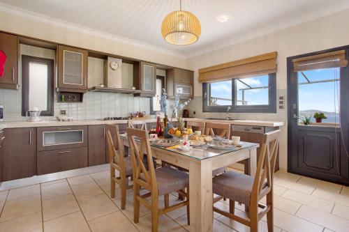 a kitchen with a table and chairs and a kitchen with a window at Zante Sunset Vibes Luxury Villa in Áno Yerakaríon