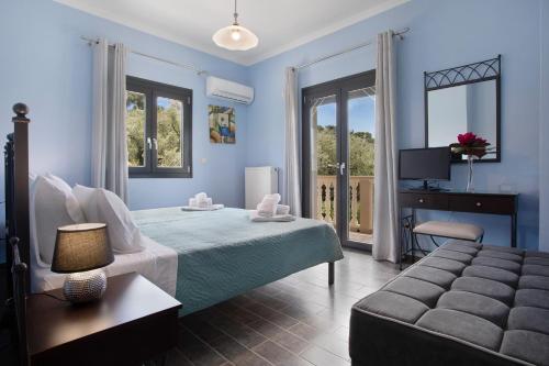 a blue bedroom with a bed and a desk and a couch at Zante Sunset Vibes Luxury Villa in Áno Yerakaríon