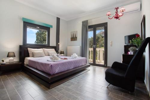 a bedroom with a bed and a chair and windows at Zante Sunset Vibes Luxury Villa in Áno Yerakaríon