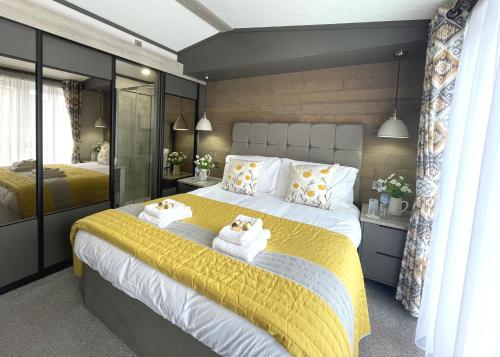 アナンにあるBeautiful Luxury Lakeside Lodge Hot Tub Views Pass the Keysのベッドルーム1室(大型ベッド1台、タオル付)