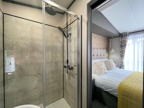 アナンにあるBeautiful Luxury Lakeside Lodge Hot Tub Views Pass the Keysのバスルーム(シャワー付)、ベッド1台が備わります。