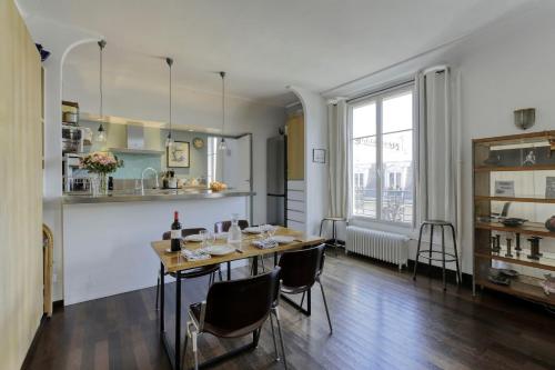 une cuisine et une salle à manger avec une table et des chaises dans l'établissement Le Petit Parisien - Au Cœur de Montparnasse, à Paris