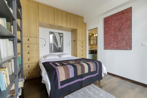 une chambre avec un lit et une étagère dans l'établissement Le Petit Parisien - Au Cœur de Montparnasse, à Paris