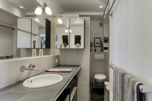 une salle de bain avec un lavabo et des toilettes dans l'établissement Le Petit Parisien - Au Cœur de Montparnasse, à Paris