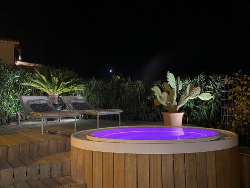 a blue circular pool with two chairs on a deck at night at House Casbah Porto Rotondo in Porto Rotondo