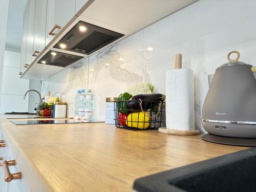 a kitchen counter with a basket of fruits and vegetables at MOVEEN! Wynajem apartamentów we Wrocławiu! 10 minut od centrum in Wrocław